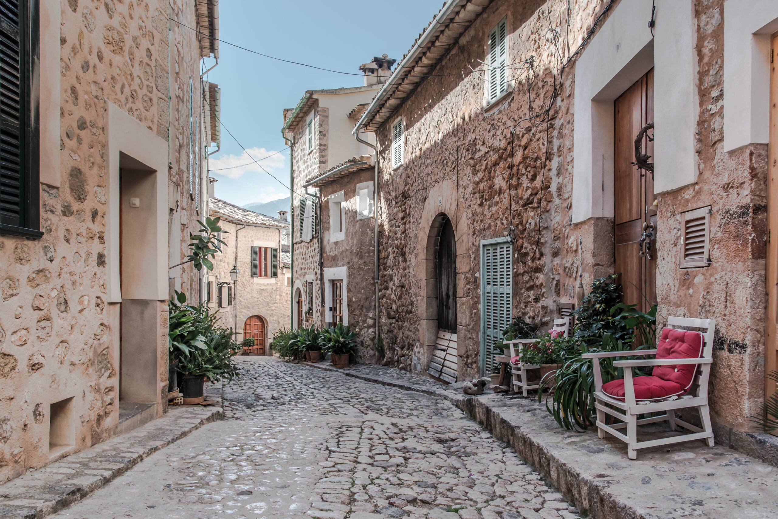 empty narrow cobbled street in small spanish village with typical houses on both sides